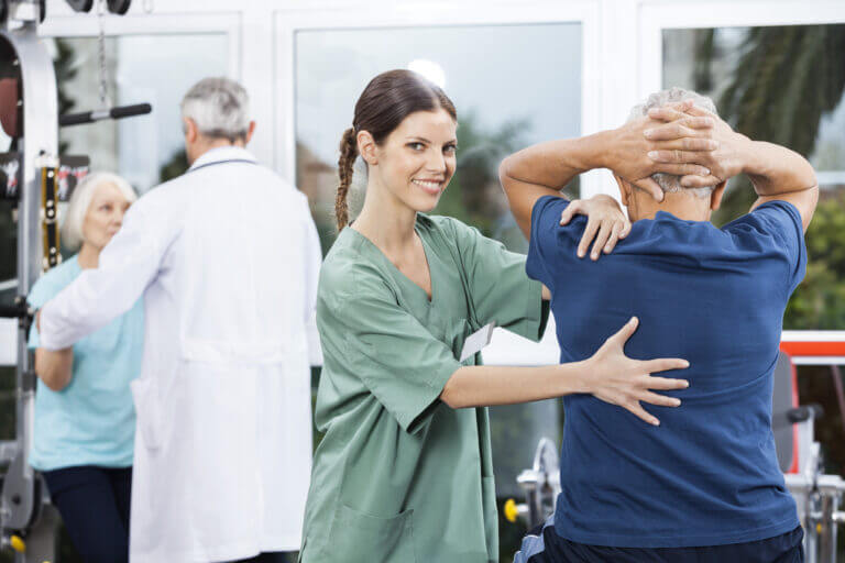 Female,Nurse,Assisting,Senior,Man,In,Back,Exercise