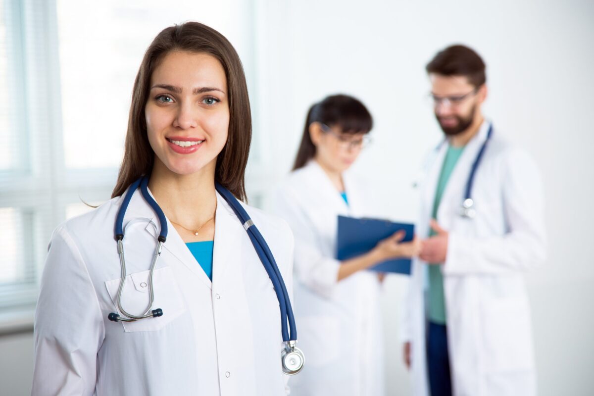 Portrait Of A Young Female Doctor In A Clinic With Colleagues On The Background