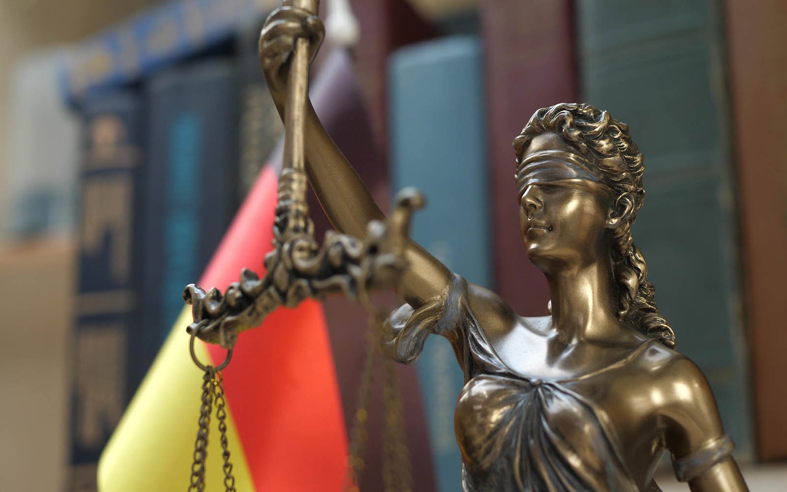 Statue,Of,Lady,Justice,With,Bookshelf,With,Books,And,Germany