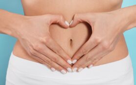 Woman,Making,Heart,With,Hands,On,Her,Belly,Against,Light