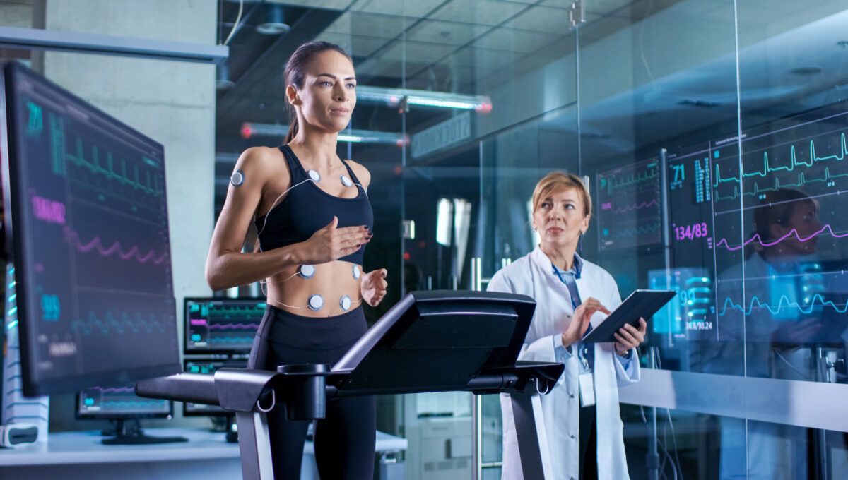 Beautiful,Woman,Athlete,Runs,On,A,Treadmill,With,Electrodes,Attached
