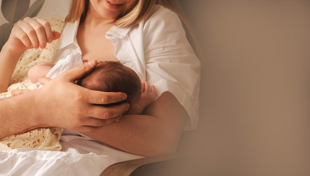 Young,Mother,Holding,And,Breastfeeding,Her,Newborn,Baby.,Father's,Hand