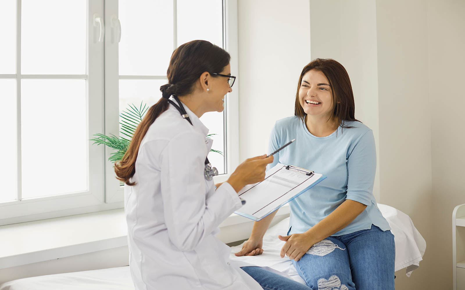 Doctor,Discussing,Treatment,With,Cheerful,Smiley,Female,Patient.,Happy,Physician