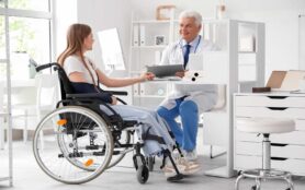 Young,Woman,In,Wheelchair,With,Broken,Arm,Visiting,Doctor,At