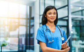 Caucasian,Female,Practitioner,Working,At,Reception,Desk,While,Answering,Phone