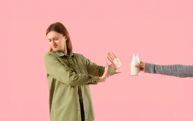 Displeased,Woman,With,Lactose,Intolerance,Rejecting,Milk,On,Pink,Background