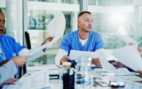 Doctors,,Nurses,And,Man,In,Meeting,With,Paperwork,For,Hospital