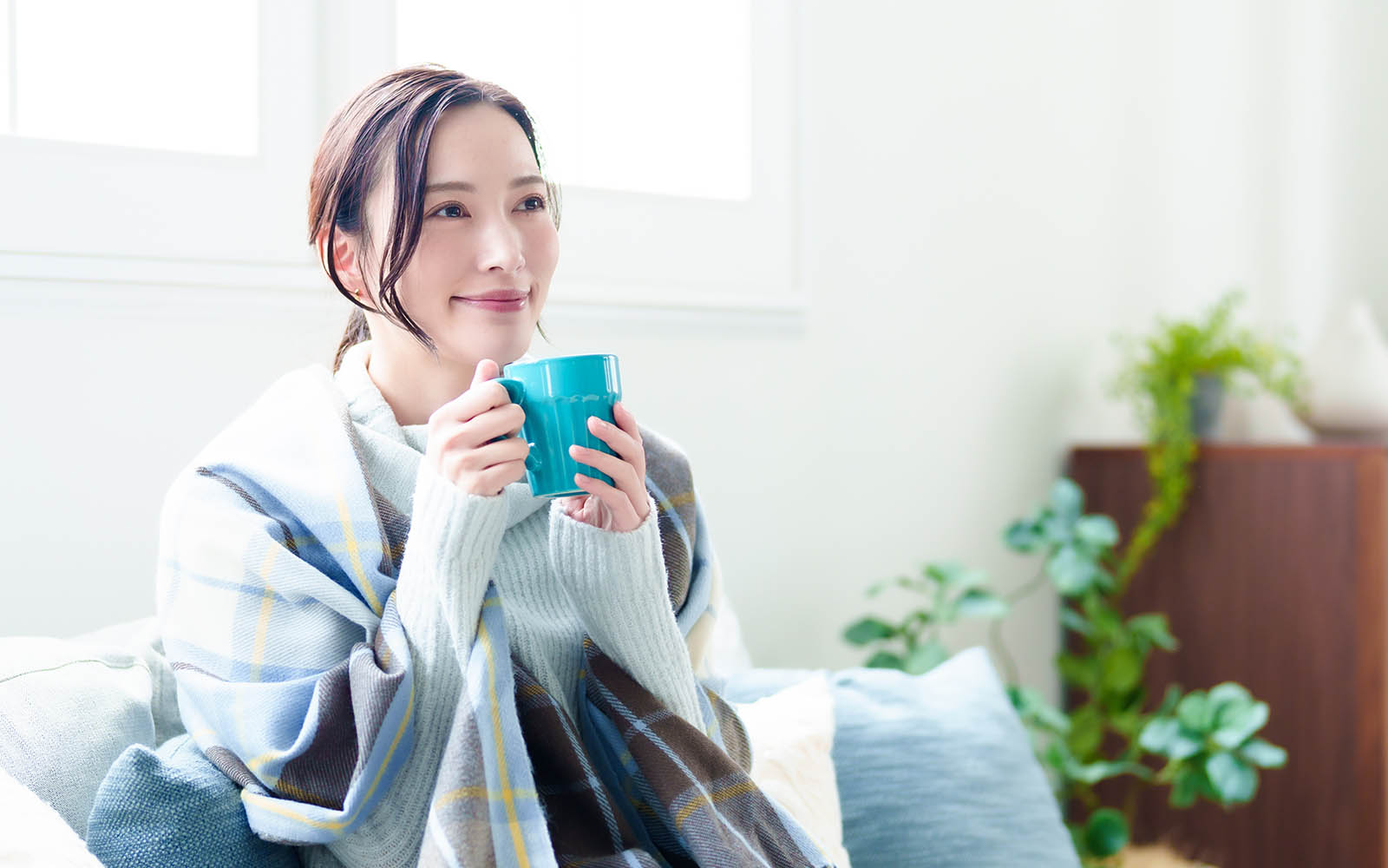 Attractive,Asian,Woman,Relaxing,And,Drinking,Hot,Beverage,On,Sofa