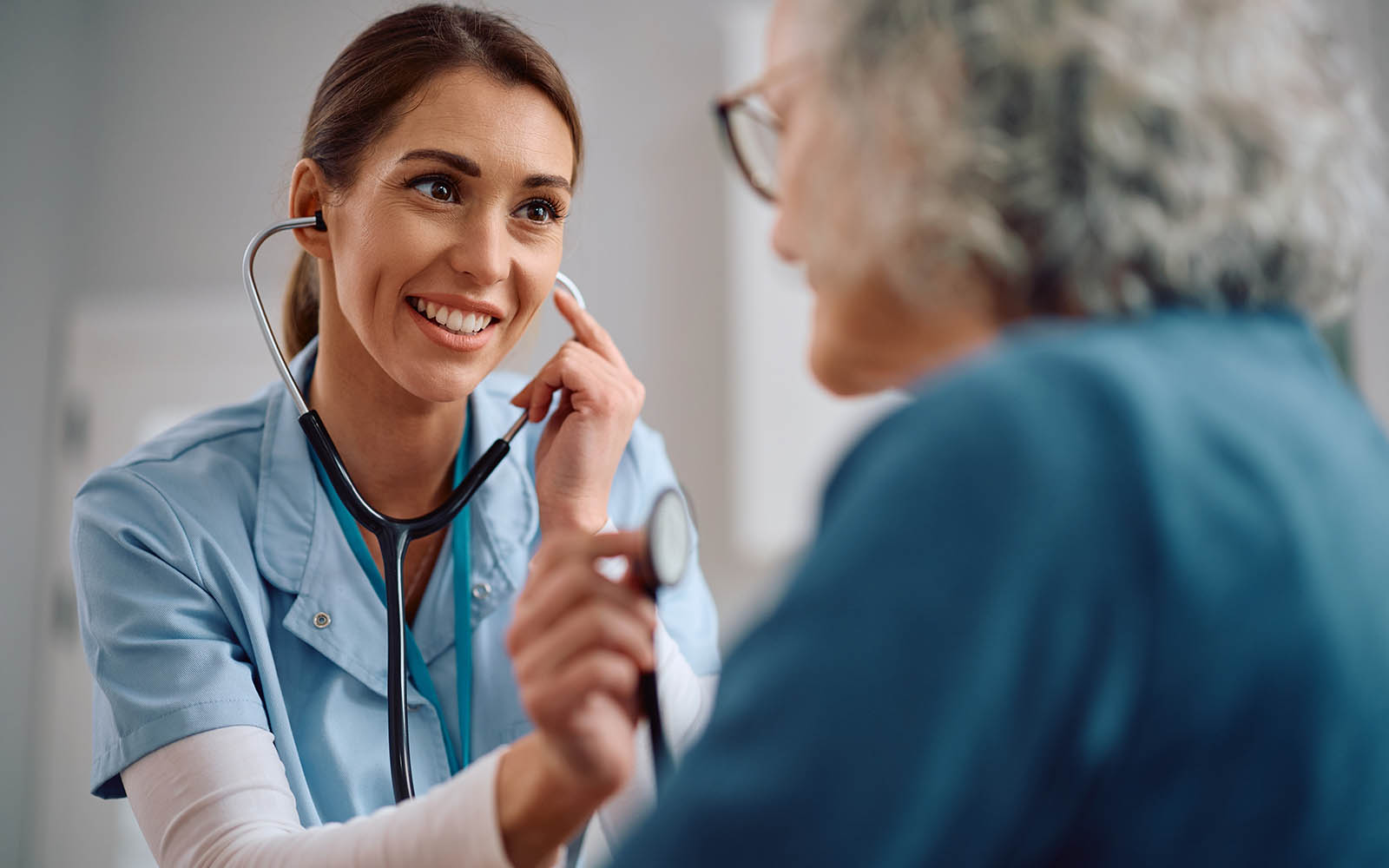 Happy,Nurse,Checking,Heartbeat,Of,Senior,Patient,With,A,Stethoscope