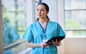 Professional,Female,Nurse,In,Scrubs,With,Digital,Tablet,At,Hospital